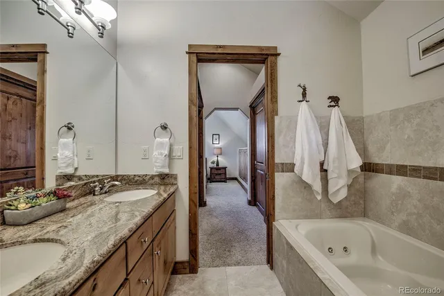 a en suite bathroom with a granite countertop sink and a mirror