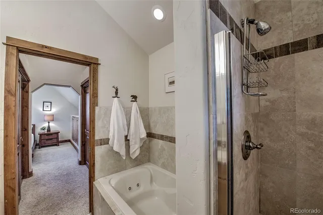 a bathroom with a tub a sink and mirrors
