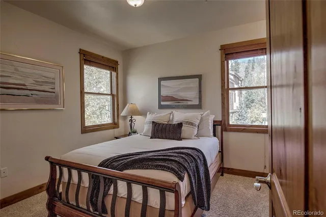 a bedroom with a bed and windows