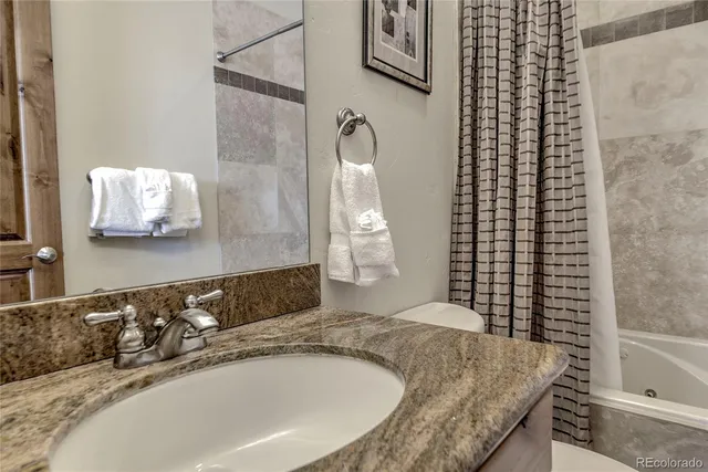 a bathroom with a granite countertop bathtub and a sink