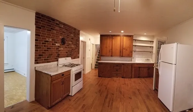 a kitchen with a wooden floor and a refrigerator