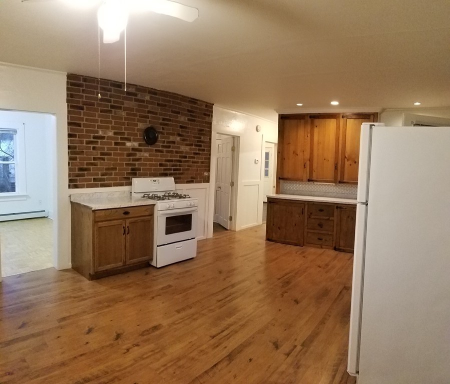 63 Harrington Street, Unit 2 Southbridge, MA 01550 - Photo 4 of 15 a kitchen with stainless steel appliances granite countertop a stove and a refrigerator
