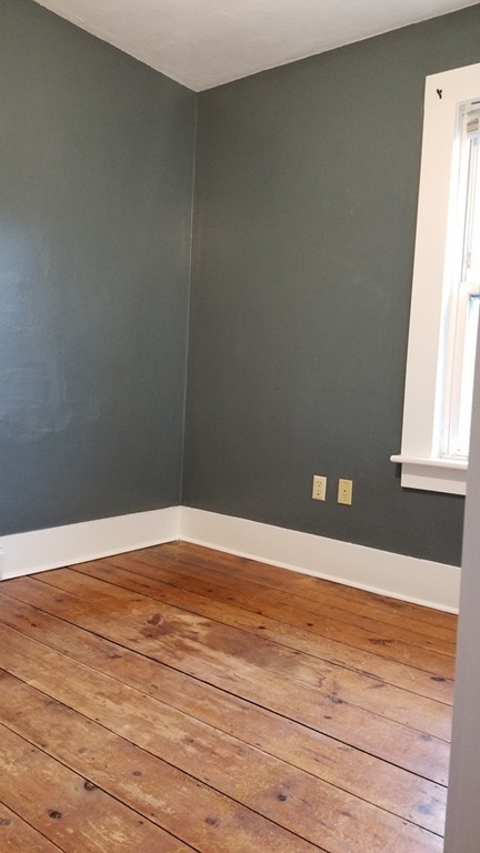 63 Harrington Street, Unit 2 Southbridge, MA 01550 - Photo 9 of 15 a view of an empty room with wooden floor and a window