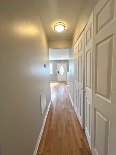 a view of a hallway with wooden floor