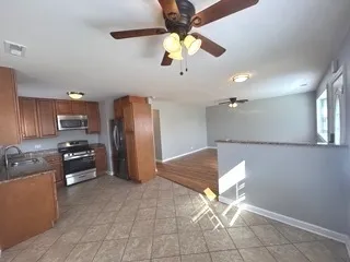 a kitchen with stainless steel appliances granite countertop a refrigerator a stove and a sink