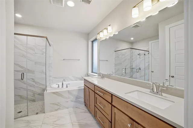 a spacious bathroom with a double vanity sink mirror and shower