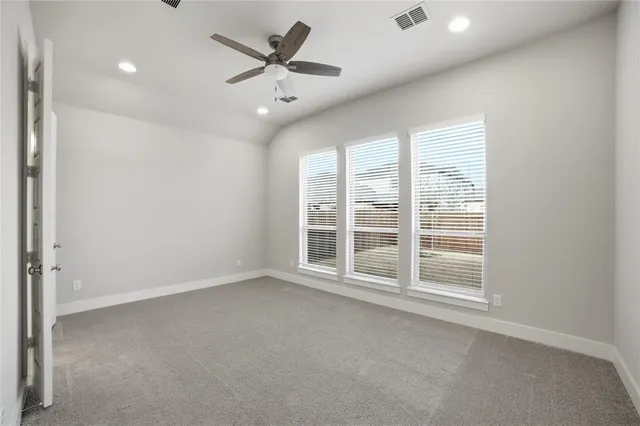 an empty room with a ceiling fan and window