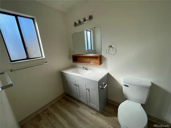 a bathroom with a toilet sink and mirror