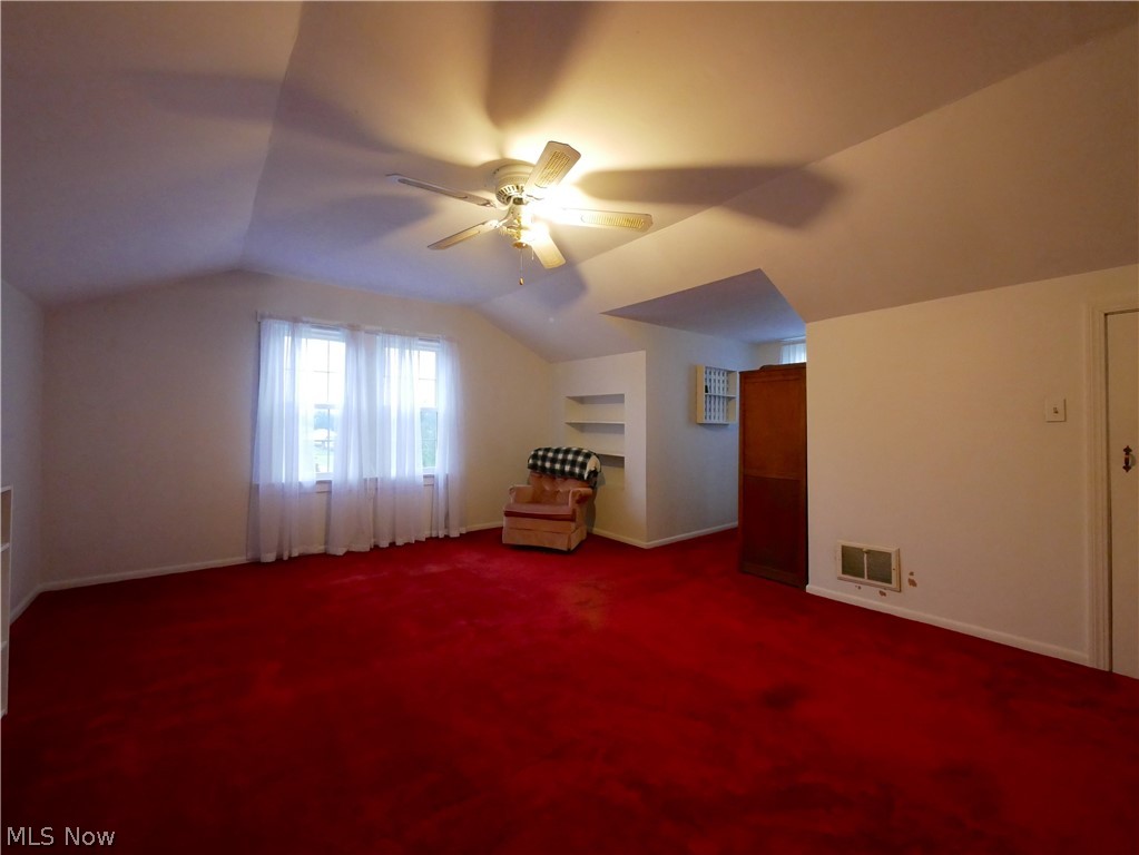 72622 Colerain Road Dillonvale, OH 43917 - Photo 10 of 17 Vaulted ceiling with an integrated ceiling fan, window with white sheer curtains, built-in shelving, and red carpeting