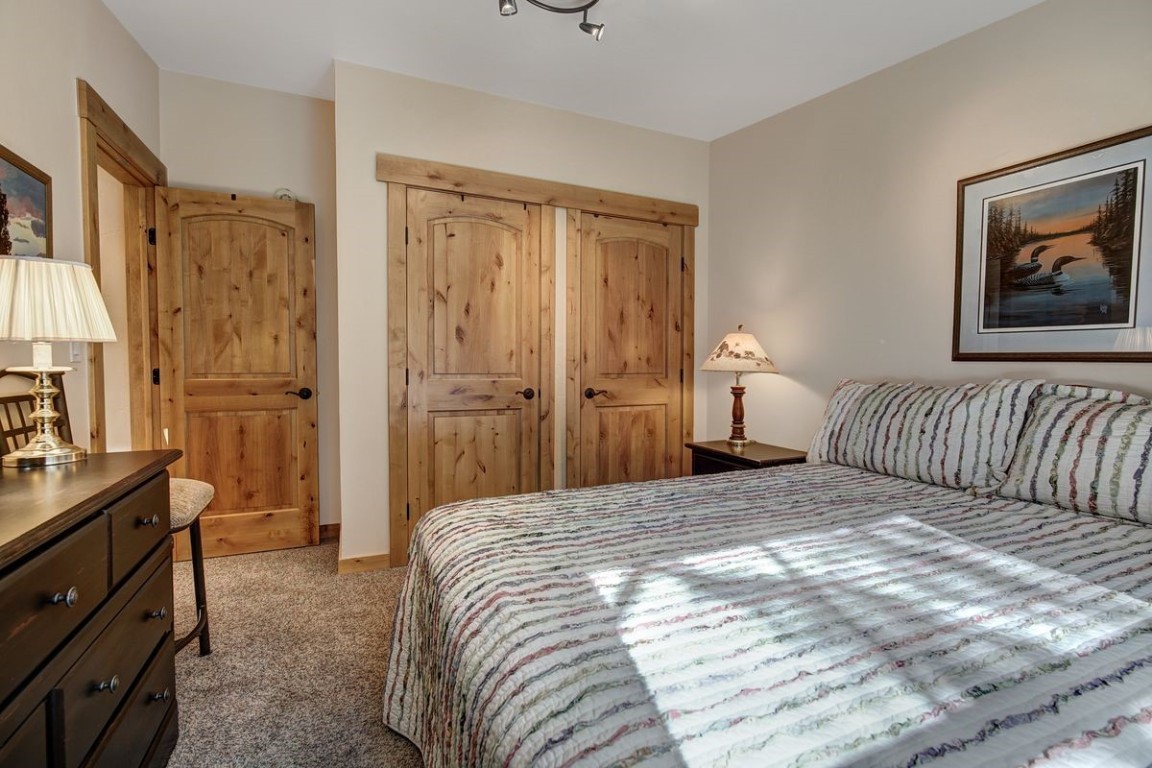 379 Hummingbird Circle Silverthorne, CO 80498 - Photo 16 of 44 a bedroom with a bed and a lamp