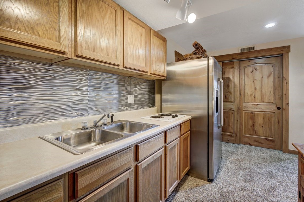 379 Hummingbird Circle Silverthorne, CO 80498 - Photo 26 of 44 a kitchen with stainless steel appliances granite countertop a sink and a refrigerator