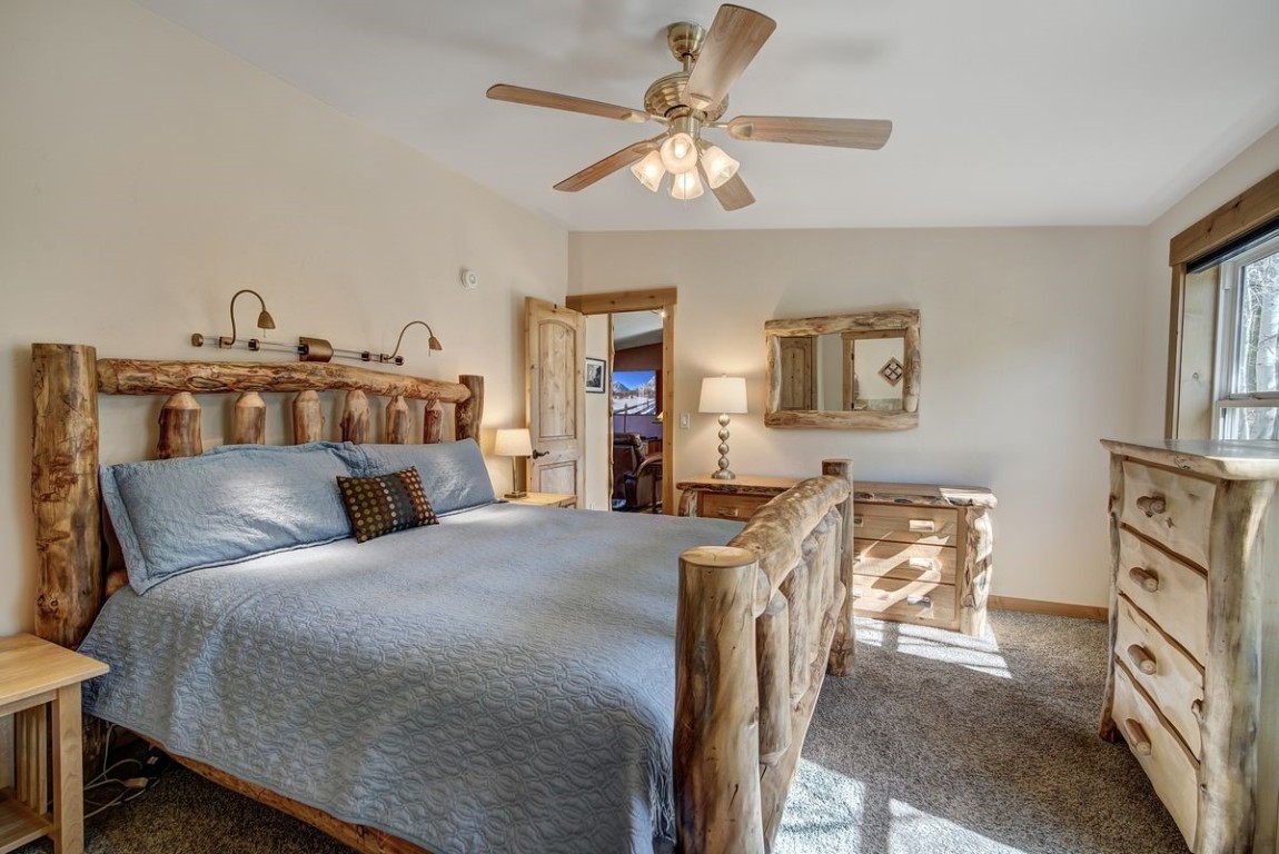 379 Hummingbird Circle Silverthorne, CO 80498 - Photo 4 of 44 a bedroom with a bed and a chandelier