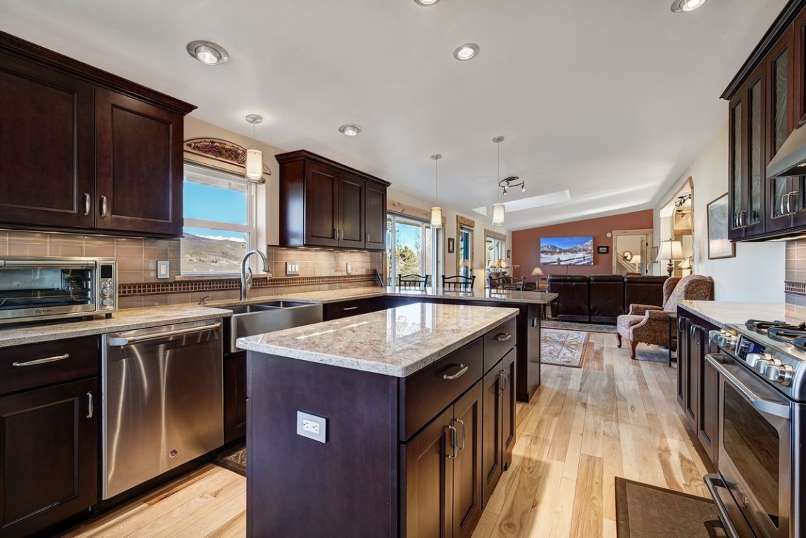 379 Hummingbird Circle Silverthorne, CO 80498 - Photo 9 of 44 a kitchen with stainless steel appliances granite countertop a stove top oven a sink dishwasher and a refrigerator with wooden cabinets