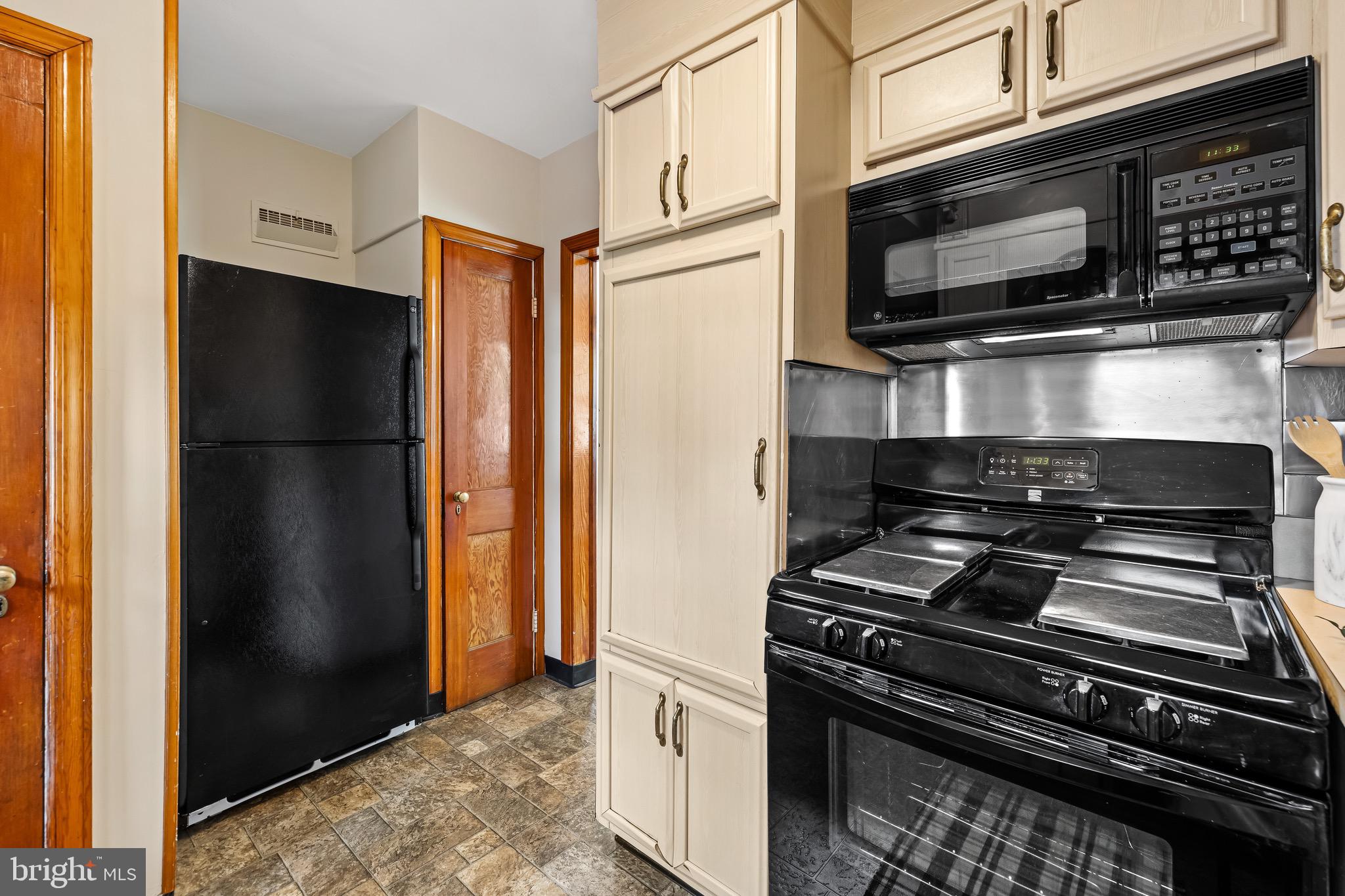 6806 Dunhill Road Baltimore, MD 21222 - Photo 11 of 45 a kitchen with a stove microwave and refrigerator