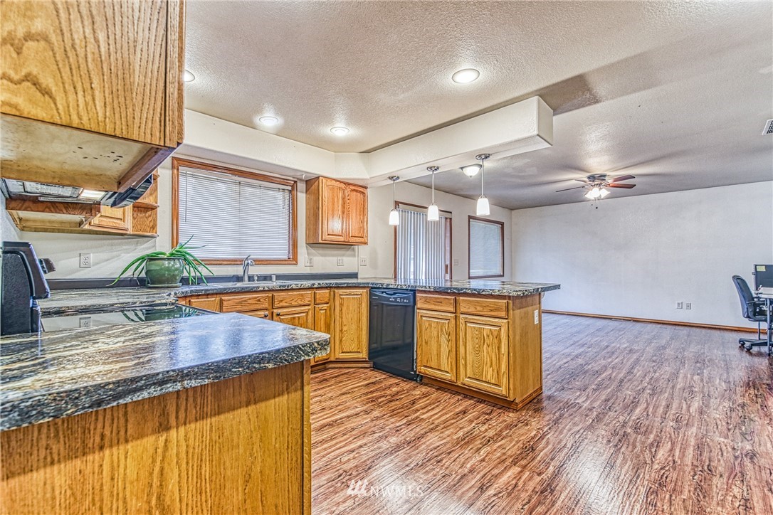 18212 Empire Street Southwest Rochester, WA 98579 - Photo 7 of 29 a kitchen with stainless steel appliances granite countertop a sink a stove cabinets counter space and wooden floor