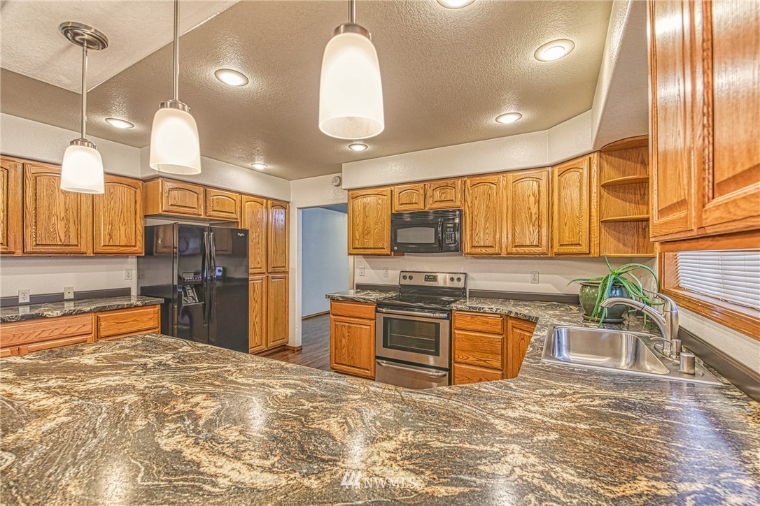 18212 Empire Street Southwest Rochester, WA 98579 - Photo 8 of 29 a kitchen with stainless steel appliances granite countertop a stove a sink and a refrigerator