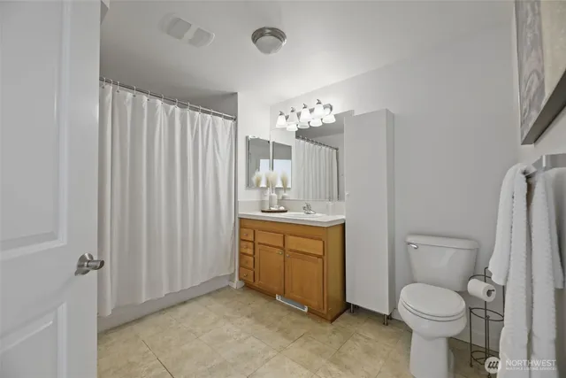 a bathroom with a granite countertop toilet sink and mirror
