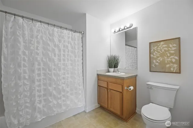 a bathroom with a granite countertop toilet sink and mirror