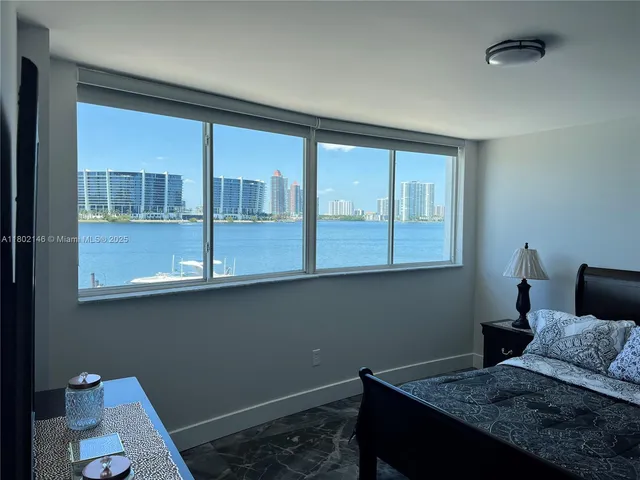 a bed sitting in a bedroom next to a window with chair