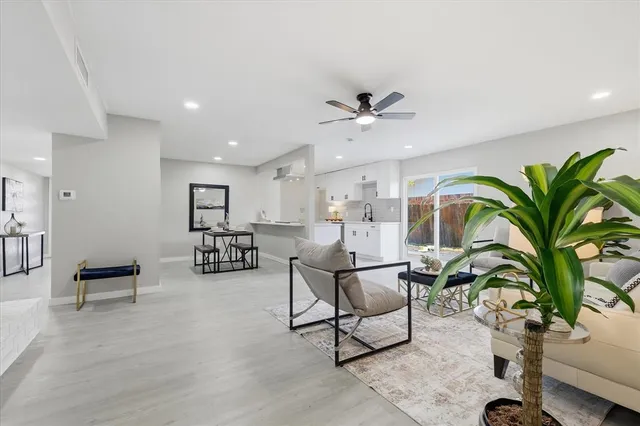 a living room with furniture a potted plant and a table
