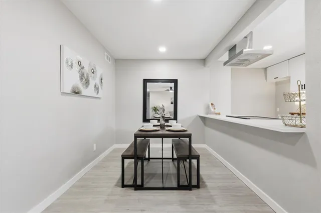 a dining room with wooden floor and a chandelier