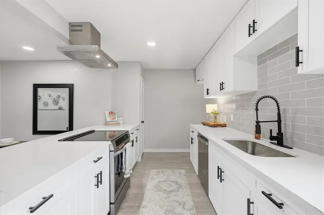 a kitchen with a sink and a stove top oven