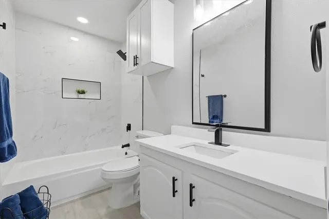 a bathroom with a sink a toilet and a large mirror
