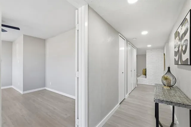a hallway with sliding door and wooden floor