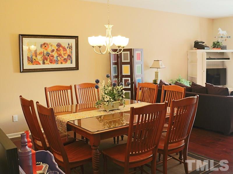 1045 Ileagnes Road Raleigh, NC 27603 - Photo 8 of 22 a dining room with furniture a rug and wooden floor