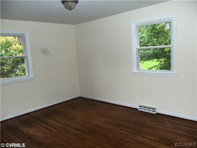 1209 Covington Road Colonial Heights, VA 23834 - Photo 9 of 12 an empty room with wooden floor and windows