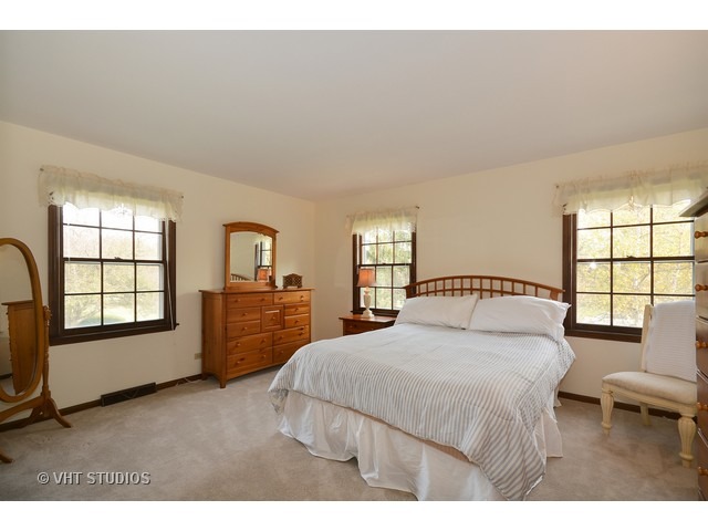 5N316 Oak Road St. Charles, IL 60175 - Photo 18 of 25 a bedroom with a bed a couch and dresser with wooden floor