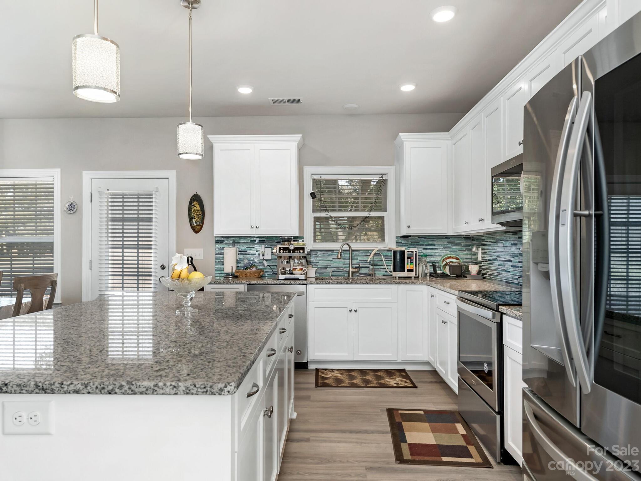 3324 Sincerity Road Monroe, NC 28110 - Photo 7 of 24 a kitchen with stainless steel appliances granite countertop a sink a stove and a refrigerator