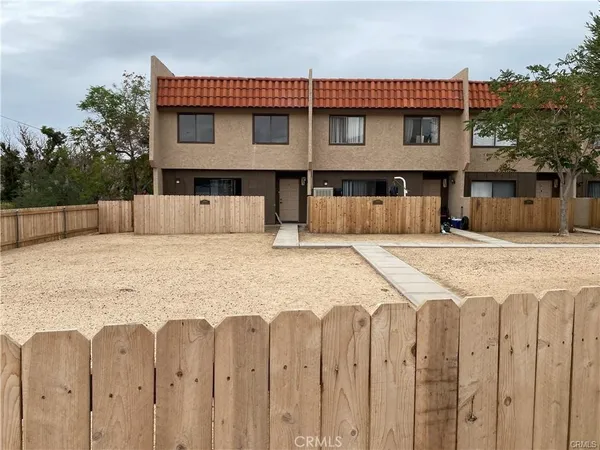 a view of a house with wooden fence and a stairs
