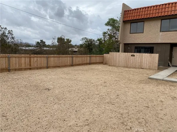 a view of backyard with small cabin and wooden fence