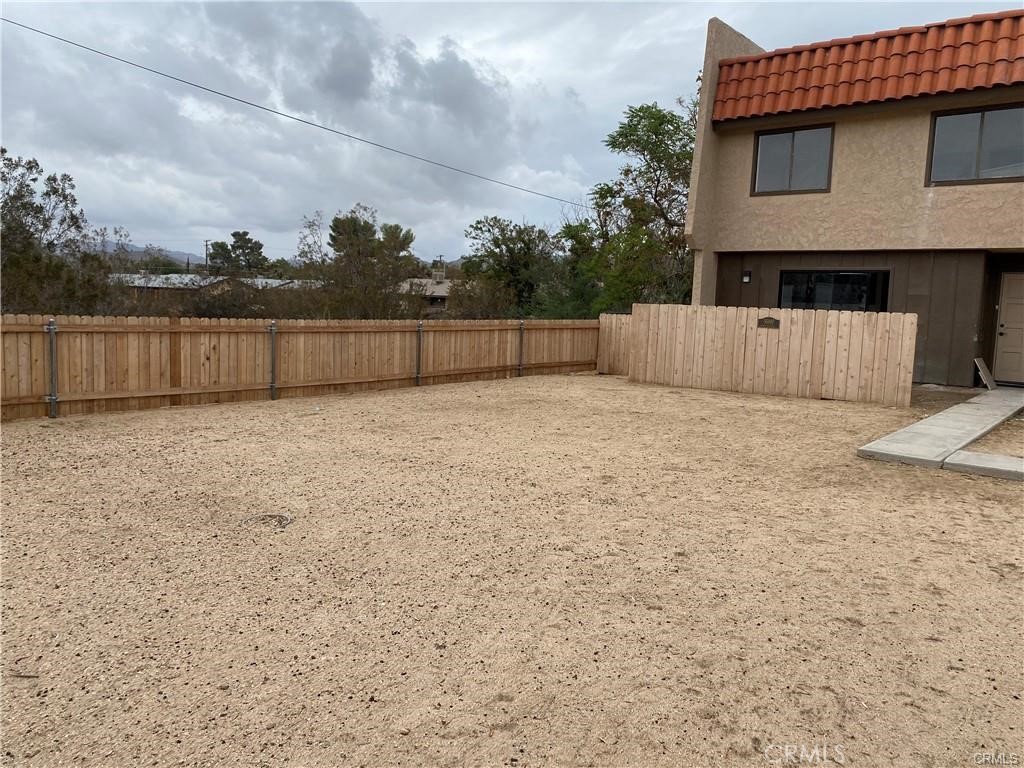 55897 Santa Fe Trail Yucca Valley, CA 92284 - Photo 3 of 4 a view of backyard with small cabin and wooden fence