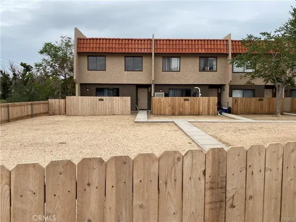 a view of a house with wooden fence and a stairs
