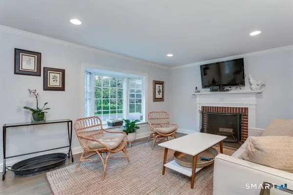 a living room with furniture a flat screen tv and a fireplace