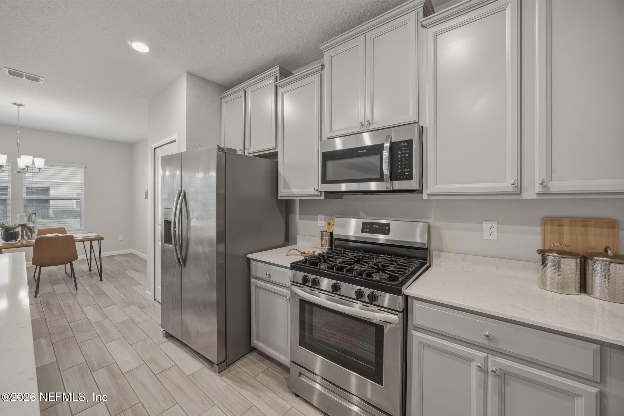 3841 Heatherbrook Place Middleburg, FL 32068 - Photo 14 of 39 a kitchen with stainless steel appliances granite countertop a stove a refrigerator and a microwave