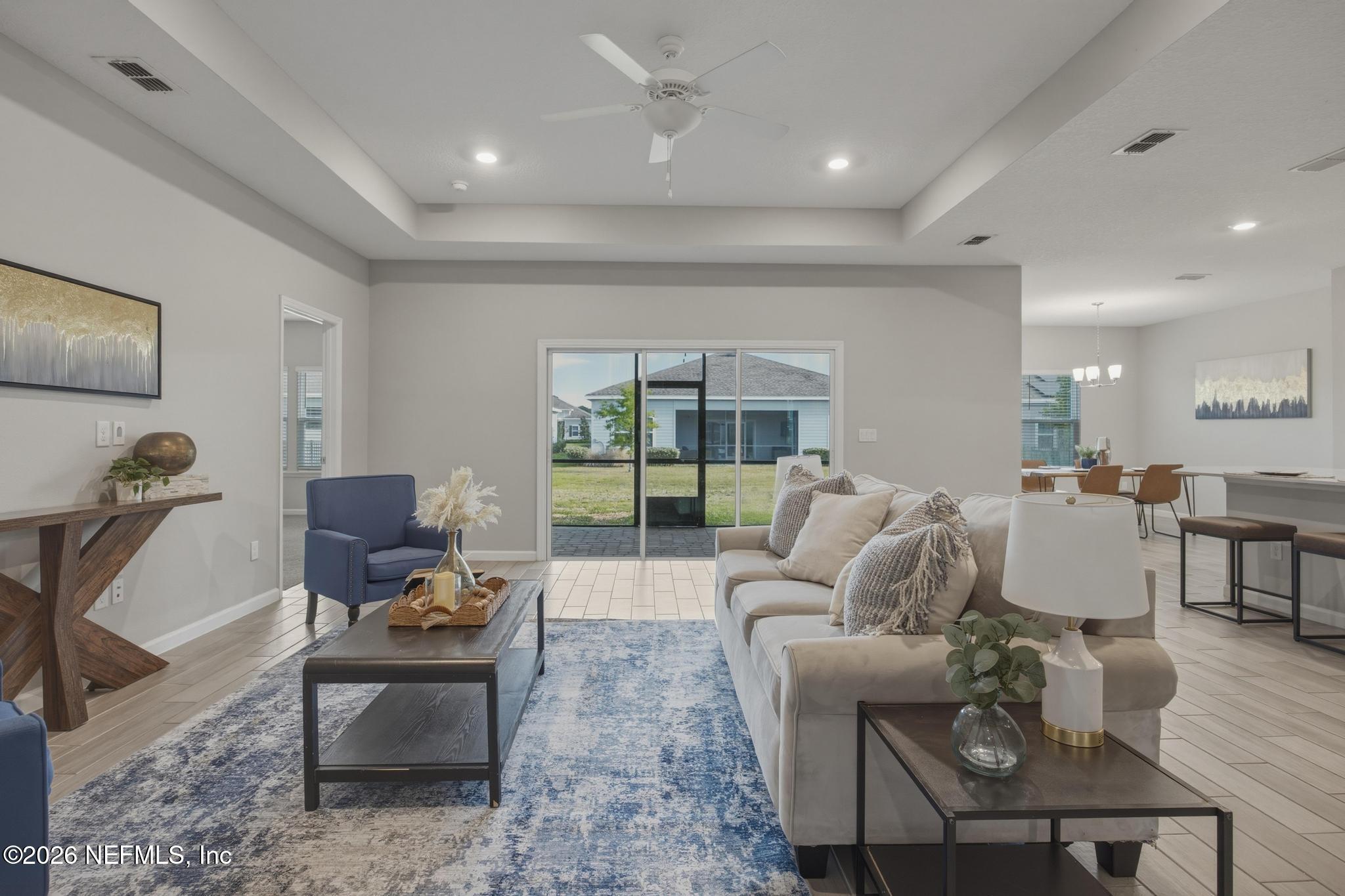 3841 Heatherbrook Place Middleburg, FL 32068 - Photo 7 of 39 a living room with furniture a couch and a floor to ceiling window
