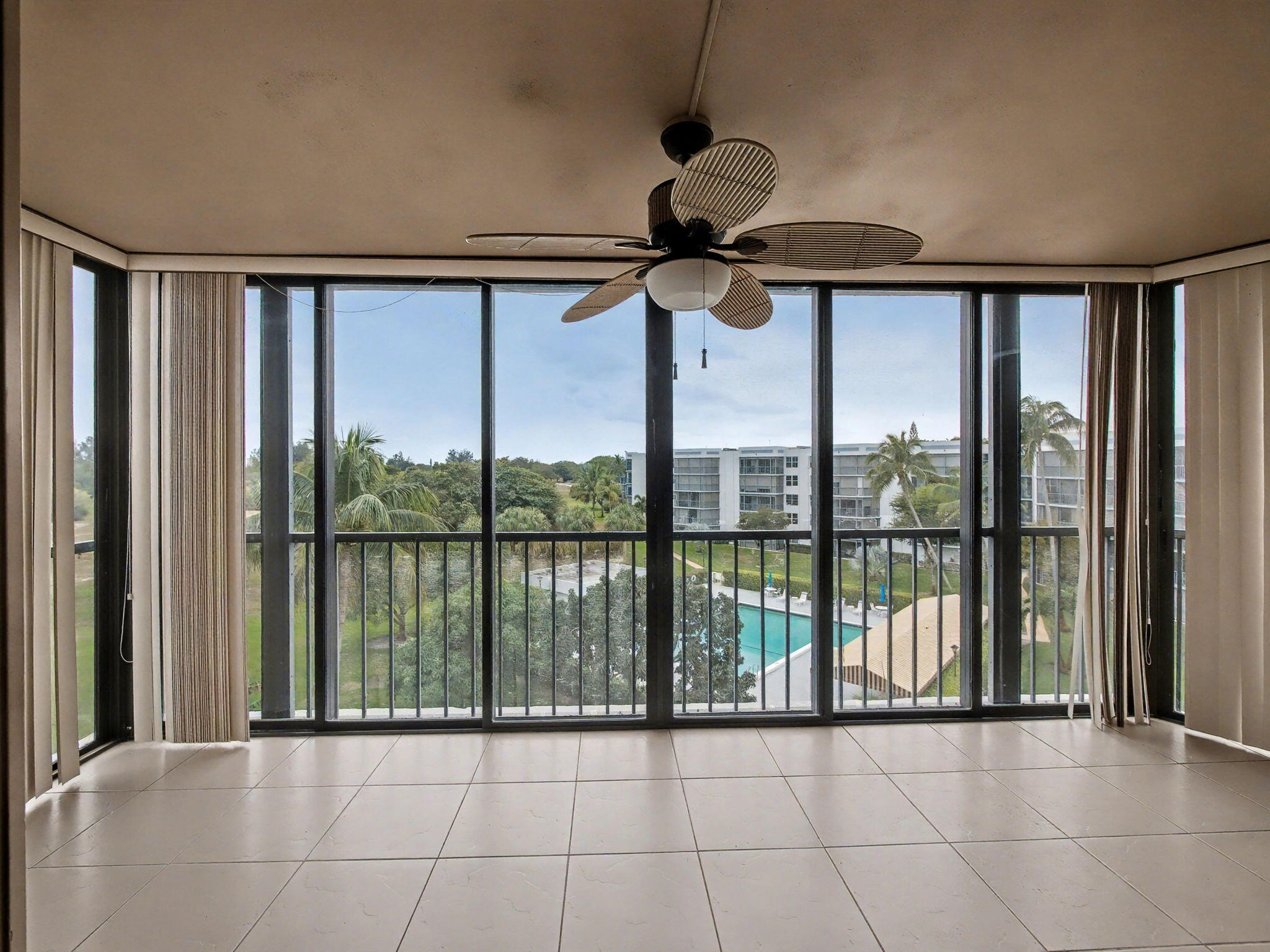 198 Northwest 67th Street, Unit 505 Boca Raton, FL 33487 - Photo 8 of 15 a view of a livingroom with a floor to ceiling window and a ceiling fan