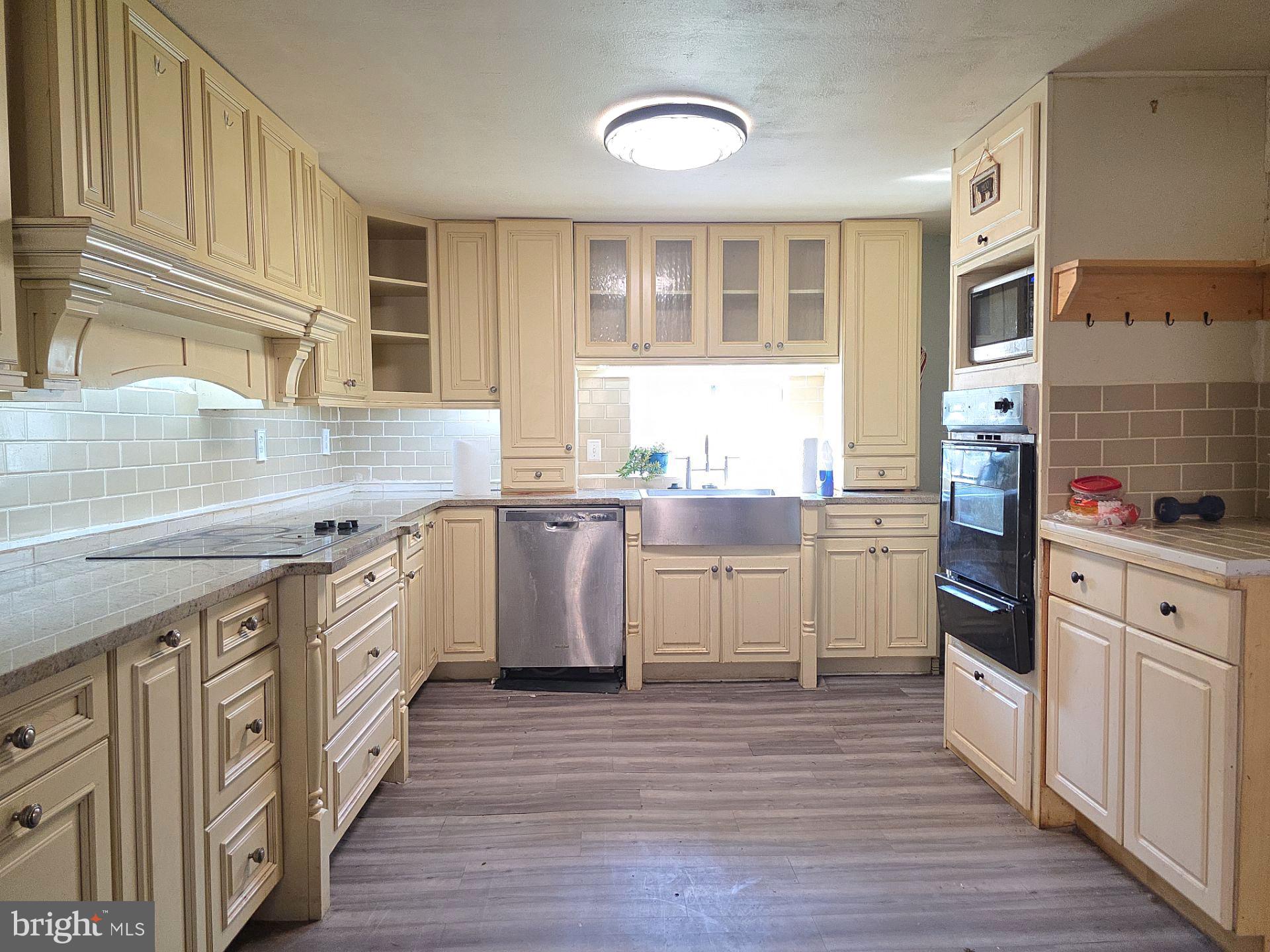 44 Highland Avenue Clementon, NJ 08021 - Photo 22 of 37 a kitchen with granite countertop a sink cabinets wooden floor and stainless steel appliances