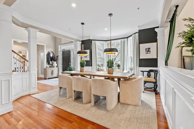 a view of a dining room and livingroom with furniture wooden floor a chandelier