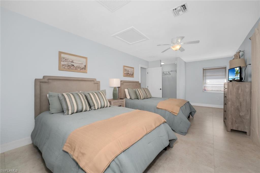 385 Willet Avenue Naples, FL 34108 - Photo 12 of 19 a bedroom with two beds and painting on the wall