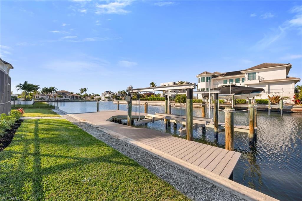 385 Willet Avenue Naples, FL 34108 - Photo 3 of 19 a view of a lake with lawn chairs and a table