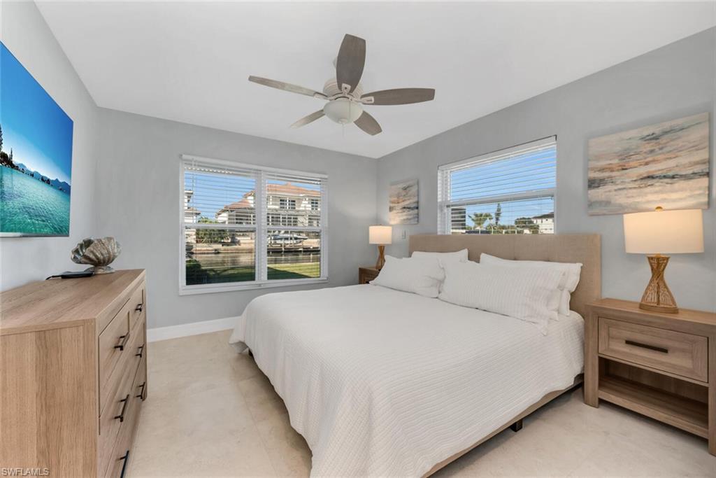 385 Willet Avenue Naples, FL 34108 - Photo 10 of 19 a bedroom with a large bed and a chandelier