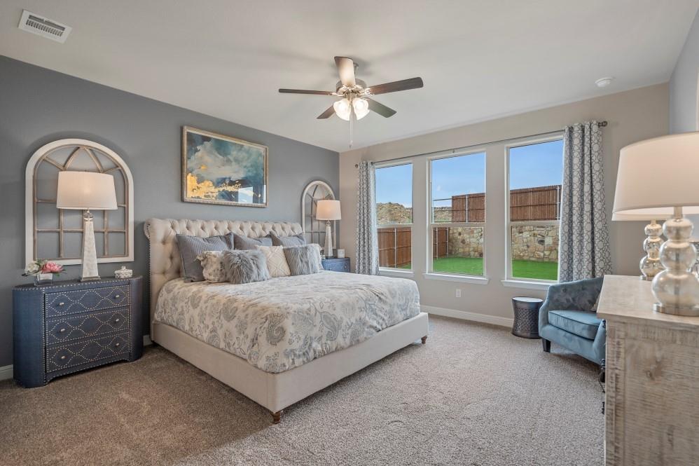 118 Stanton Avenue Rhome, TX 76078 - Photo 14 of 30 a spacious bedroom with a bed a couch and a large window