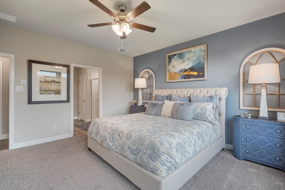118 Stanton Avenue Rhome, TX 76078 - Photo 15 of 30 a bedroom with a bed and a chandelier