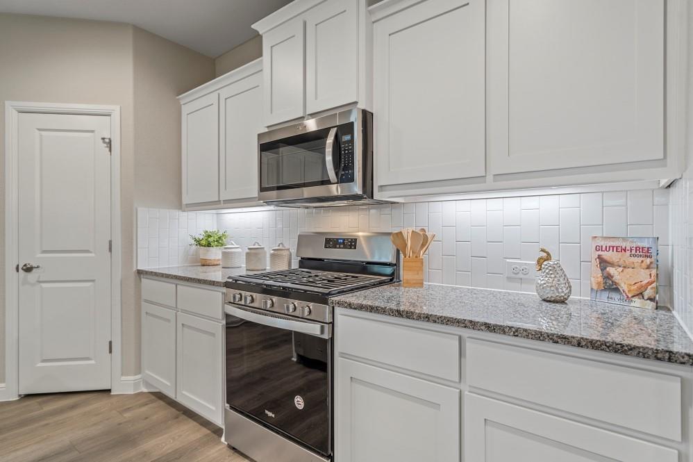 118 Stanton Avenue Rhome, TX 76078 - Photo 2 of 30 a kitchen with granite countertop white cabinets and appliances