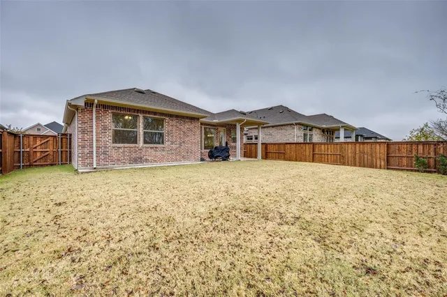 a view of a house with a yard and wooden fence
