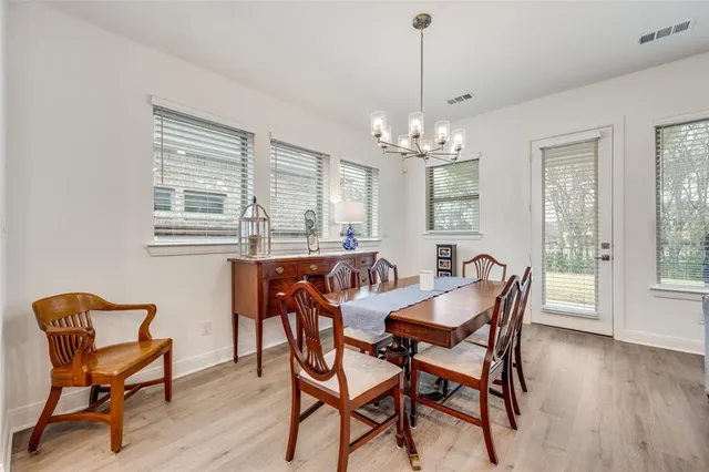 a dining room with furniture a chandelier and wooden floor